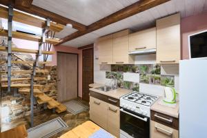a kitchen with wooden cabinets and a stove top oven at Poilsis Preiloje-91 in Neringa