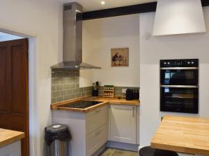 a kitchen with a sink and a stove top oven at Acorn Lodge Cottage in Keswick