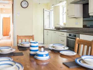 eine Küche mit einem Tisch mit blauen und weißen Platten darauf in der Unterkunft Island View - Cottage in Aberdaron
