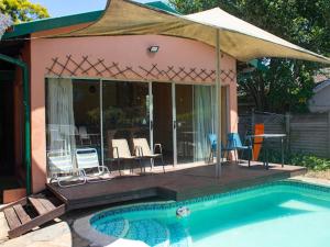a house with a swimming pool and a patio with chairs at Evergreen guest house in Pietermaritzburg +18 photos