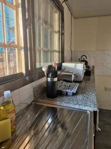 a kitchen counter with a pot on a stove at Palm and Pillow in Freetown