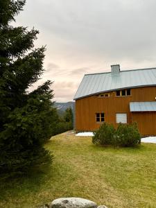 a barn on a field next to a tree at Chalet close to the Clouds in Špindlerův Mlýn