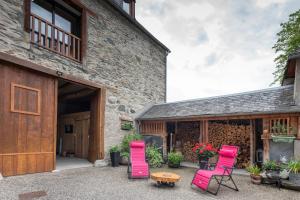 a group of pink chairs sitting outside of a building at Maison de charme à Guchan avec vue sur la montagne et jacuzzi in Guchen