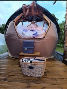 a bed in a tent with a basket next to it at Dôme étoilé in Pléneuf-Val-André