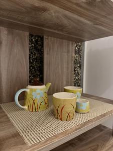 a shelf with three vases and cups on it at Camera dell' antico Arco Romano in Pozzuoli