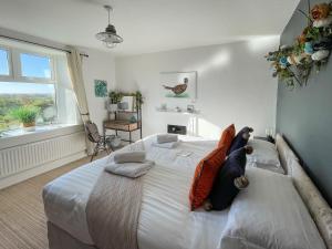 Un dormitorio con una gran cama blanca con almohadas. en Dunmail House, en Grange-over-Sands 23 fotos más