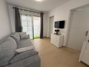 a living room with a couch and a tv at Oceanica home in Mogán