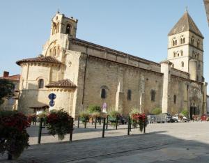 a large building with a tower and a church at Le Lagon in Saint-Gaudens