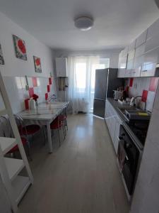 une cuisine avec une table et une cuisine avec une cuisinière dans l'établissement Apartament Abby, à Sighişoara