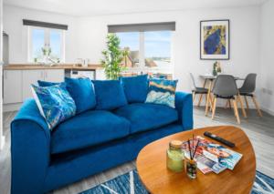 un canapé bleu dans un salon avec une table dans l'établissement 2 Bed Apartment - Parking - Sleeps 3 - Netflix 50C, à Sleightholme