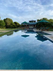 a large pool of blue water in front of a building at Raalmadu Wilpattu in Achchamulai