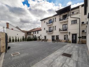 an empty parking lot in front of a white building at Casa Breslelor in Sibiu