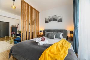 ブラショヴにあるMountain Breeze Luxury Apartment AC & Parcare Privatăのタオルが敷かれた大きなベッドのある寝室