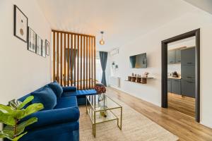 ブラショヴにあるMountain Breeze Luxury Apartment AC & Parcare Privatăの青いソファとテーブルのあるリビングルーム