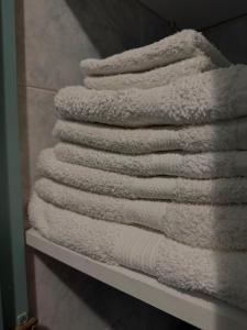 a stack of towels on a shelf in a bathroom at Camera dell' antico Arco Romano in Pozzuoli