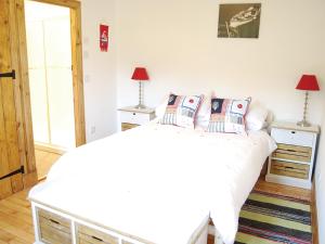 ein Schlafzimmer mit einem Bett mit weißen Laken und Kissen in der Unterkunft Shore Cottage - S4600 in Tarbert