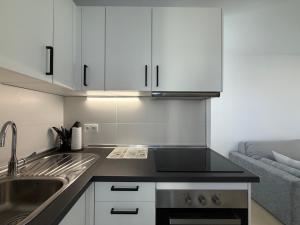 a kitchen with white cabinets and a sink at Oceanica home in Mogán