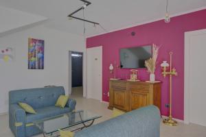 Una sala de estar con dos sillas azules y una pared morada. en Il Roseto dei Sensi, en Tarantasca