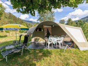 a tent with a table and chairs and an umbrella at Oh! Campings - Medrose Camping Ardèche in Saint-Thomé +14 photos