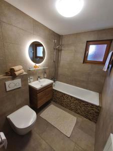 ein Badezimmer mit Toilette, Badewanne und Waschbecken in der Unterkunft Apartment Panorama in Eischoll