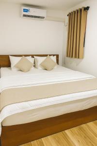 a bed with white sheets and pillows in a room at Noa Sands By Ceylon Vistas in Talpe