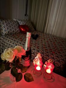 a bottle of wine and candles on a bed at Charmoso e bem localizado! in Tijucas