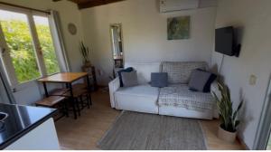 a living room with a white couch and a table at Adorable microcasa a 4km del centro de Maldonado y de playa mansa, en barrio muy tranquilo! in Maldonado