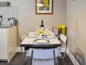 a table with wine glasses and a bowl of grapes on it at Riverside Cottage in Blair Atholl