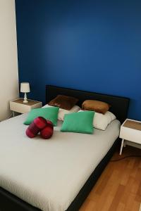 Una cama con almohadas verdes y rojas. en Close to Paris, Metro,RER, 6 People, PKG, en Saint-Denis