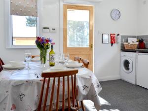a dining room table with plates and wine glasses at Wayside Cottage in Brigham +12 photos