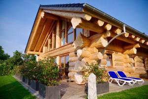 eine Blockhütte mit Stühlen und einer Wand aus Baumstämmen in der Unterkunft Blockhaus Eifelstern in Blankenheim