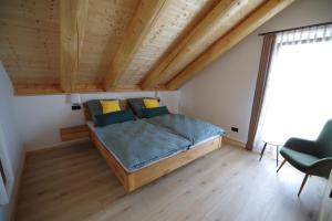 ein Bett in einem Zimmer mit Holzdecke in der Unterkunft Blockhaus Eifelstern in Blankenheim