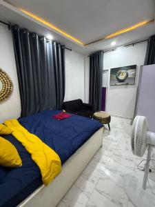 a bedroom with a blue and yellow bed and a chair at Beautiful single room studio apartment in Ilasan lekki magnanimous in Lekki