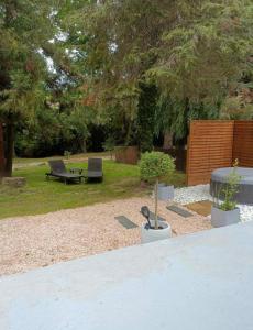 een tuin met twee banken, een tafel en een boom bij Lamaisondubois31 in Pibrac