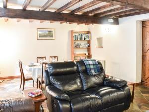 a leather chair in a living room with a table at Stable Cottage in Askrigg