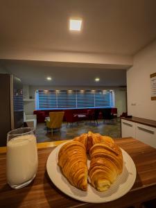 een bord croissants op tafel met een glas melk bij Residence Mahala - Boutique Guesthouse near Baščaršija in Sarajevo