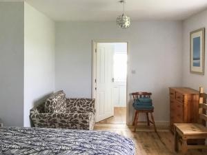 a bedroom with a bed and a chair and a door at Hempstead End in Lessingham