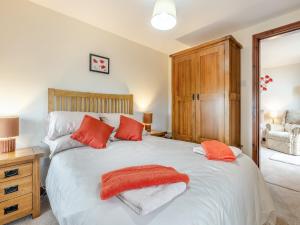 Earl SterndaleにあるPoppies Court Jericho Farmのオレンジ色の枕が付いた大きな白いベッドのある寝室
