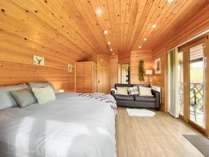 a bedroom with a large bed and a couch at Apple-Uk46285 in Camerton