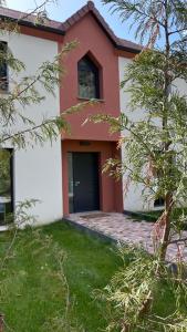 een rood-wit huis met een zwarte deur bij Paradis Rouge in Méré