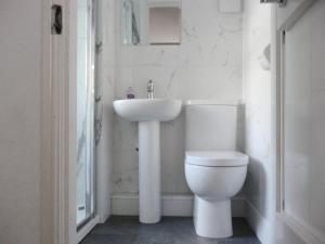 a white bathroom with a sink and a toilet at Cropple Howe in Threlkeld