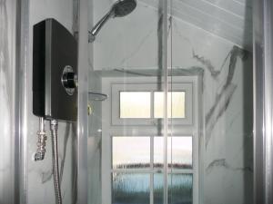a shower with a glass door and a window at Cropple Howe in Threlkeld +5 photos