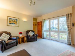 a living room with two chairs and a sliding glass door at The Milking Shed - Uk30436 in Kingsbury Episcopi