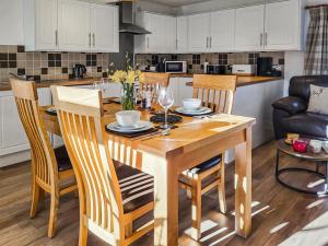 eine Küche mit einem Holztisch mit Stühlen und einem Esszimmer in der Unterkunft Jessamine Cottage in Blairgowrie + 13 Fotos