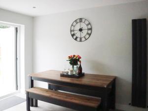 a table with flowers and a clock on a wall at 4 Mote View-Uk37497 in Sandhead