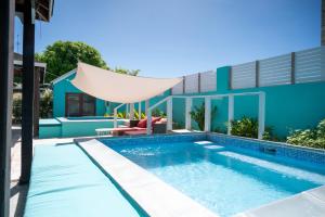 a swimming pool in front of a house at BLR Villas Dover Beach in Christ Church