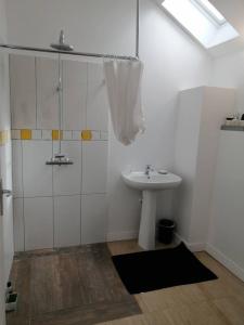 een witte badkamer met een wastafel en een douche bij A 100 m de la grande plage à Saint-Lunaire in Saint-Lunaire