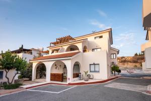 een groot wit gebouw met een parkeerplaats bij Abitare Retreat in Paphos City