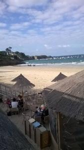 een strand met mensen in stoelen en parasols bij A 100 m de la grande plage à Saint-Lunaire in Saint-Lunaire