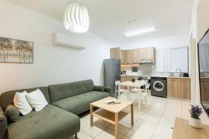 een woonkamer met een groene bank en een keuken bij Abitare Retreat in Paphos City